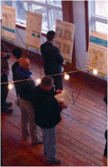Participants in an IL Route 53 planning open house review presentation boards.