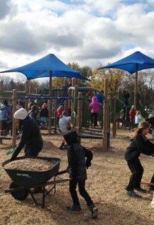 Students at William Hammerschmidt School spread mulch and play on their new playground. 