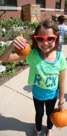 A young gardener at Hammerschmidt School shows off some of the harvest.